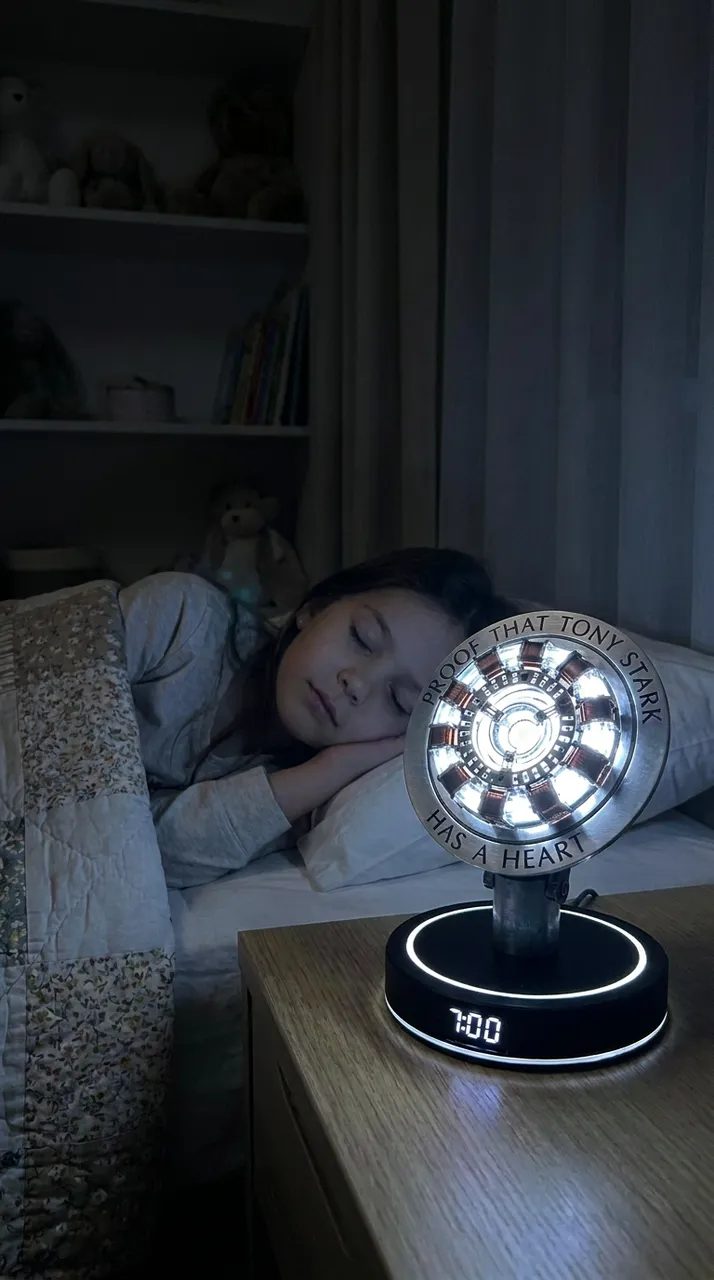Bambina a letto con la lampada sveglia di Iron Man accesa sul comodino